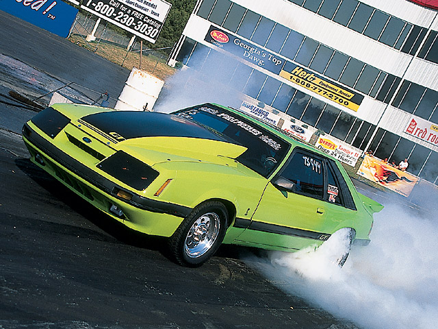 0408mm_09z 1985_Ford_Mustang_GT Front_Driver_Side_View_At_Track
